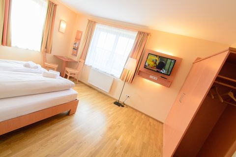 Doppelbett im Doppelzimmer im JUFA Hotel Knappenberg mit TV