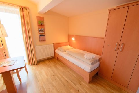 Bett im Einzelzimmer im JUFA Hotel Knappenberg mit Kleiderschran