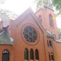 Backsteinkirche in Ostedt – neogotisches Rundfenster und Kirchturm im Grünen