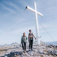 Wanderer am Gipfelkreuz der Hohen Munde