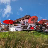 Familien-Weitwanderung im Gaistal - Familie steht auf Terasse bei der Wettersteinhütte - Vater zeigt auf etwas.jpg