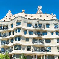 Fassade des Casa Mila mit grünen Bäumen - Barcelona