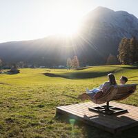 Herbstwanderung am Oberen Wiesenweg_junges Paar sitzt auf Holzliege vor Hohe Munde.jpg