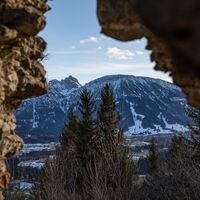 Der Breitenberg durch ein Loch in der Mauer der Ruine Hohenfreyberg gesehen