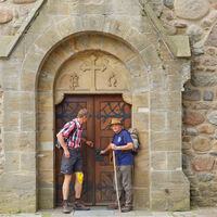 Wanderer vor dem Tor der Zevener St. Viti-Kirche