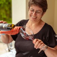 Weinverkostung bei einer Winzerin, die soeben das Glas befüllt.