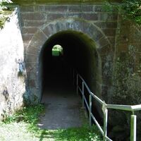 Tunnel mit Bachlauf durch den Bahndamm