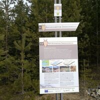 in der Nähe eines Rastplatzes eine große Wiese, östlich von Wurdach - Infotafel wird umgeben von Gesteinsarten des Sattnitzgebierges
