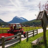 Scharnitz - Wanderung Dorfrunde - Traktor am Weg vor Pausenbank.jpg