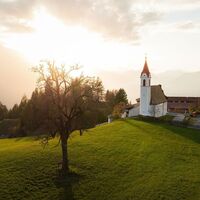 Drohnenaufnahme Mösern im Herbst_Kirche bei Sonnenuntergang.jpg