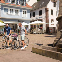 Radfahrer machen einen Zwischenstopp am Schlangenbrunnen in Blieskastel