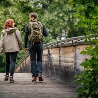 Zwei Wanderer auf einer Holzbrücke im Wald
