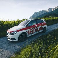 Der Heidiland E-Car fährt entlang der Reben in der Bündner Herrschaft