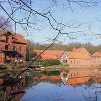 Rote Backsteingebäude der Ahauser Mühle am Mühlenteich