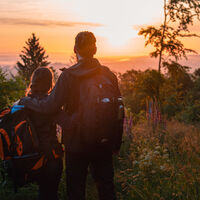 Wanderpaar vor Sonnenaufgang am Eisenberg in Korbach
