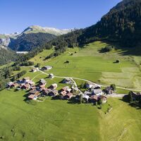 Bergdorf Pigniu mit der Staumauer im Hintergrund