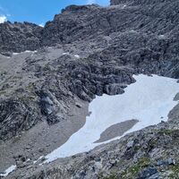 Hier nochmal der gesamte Hang: Oben links das Loch, dann die Kletterstellen über die Felsstufe zum Schneefeld, das im ganz oberen Bereich (unterhalb der Felswand) gequert wird.