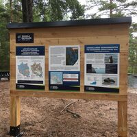 Saimaa Geopark-Wegweiser am Sandstrand von Ilkonsaari