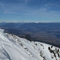 Blick über die Kärntner Ebenen zu den verschneiten Hohen Tauern.