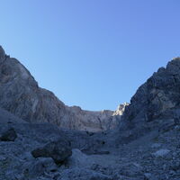 nach der Abzweigung öffnet sich dann weiter oben das Kar - hier steige ich rechts nach oben zu der etwas gelblichen Wand (großer Fels mit Höhle) und quere unter der Wand nach oben