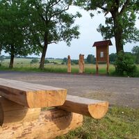 Holzskulpturen und Sitzmöglichkeit entlang des Pummpälzweges am Profischer Abzweig