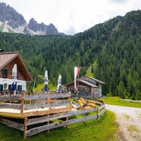 Wanderung zur Eppzirler Alm im Sommer - Mann und Frau liegen auf Liege vor der Alm - Aufnahme mit Alm und Bergpanorama.jpg