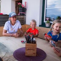 Familien-Weitwanderung im Gaistal - Familie spielt Uno auf der Wettersteinhütte - Tochter schaut Vater in die Karten.jpg