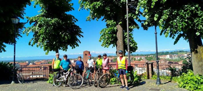 Gruppe von Radfahrern auf dem Platz vor der Kirche San Giorgio in Chieri (TO)