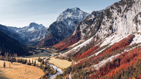 Herbst im Falzthurntal – im Zentrum des Bildes ragt das 2.457 Meter hohe Sonnjoch empor, umgeben von leuchtenden Herbstfarben der alpinen Landschaft.