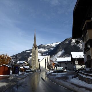 Die Pfarrkirche Maishofen und gegenüber der Gasthof Post, das Elternhaus von Anton Faistauer.