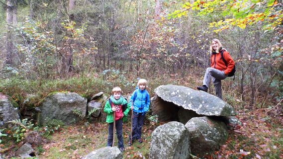Wanderer am Großsteingrab im Forst Eichholz