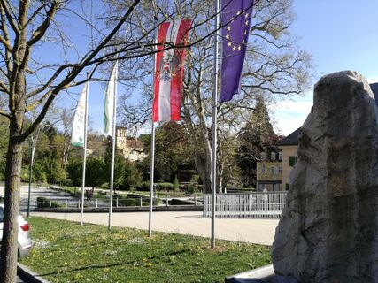 Fahnen und Infopunkt am Hauptplatz Bad Gleichenberg zur Kraftquellen-Tour im Thermen- &amp; Vulkanland Steiermark – Ausgangspunkt für spirituelle und naturnahe Entdeckungen.