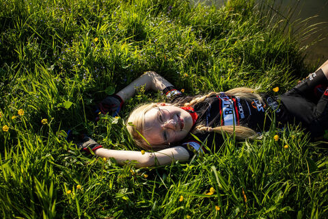 Mädchen liegt im Gras bei der Bike-Rast