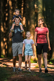 Foto Tourismus Hausruckwald/Freund der Berge: Ein Foto einer vierköpfigen Familie bei ihrer Wanderung durch den Wald.