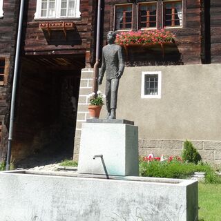 Dorfbrunnen mit Denkmal Cäsar Ritz
