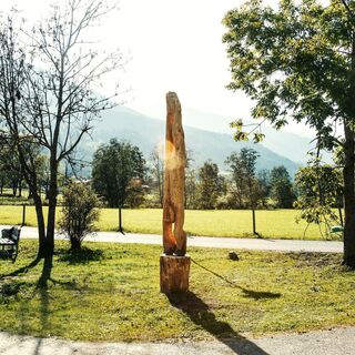 Holzskulptur „Kopfsteher“ in Naturkulisse