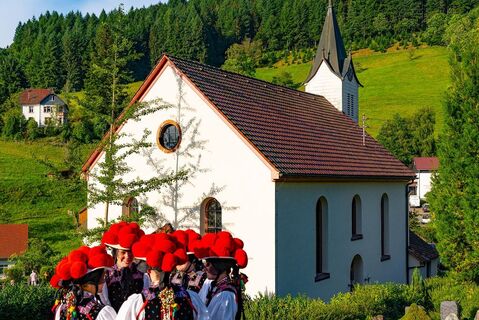 Bollenhut-Trachten vor der evangelischen Kirche St. Nikolaus Kirnbach