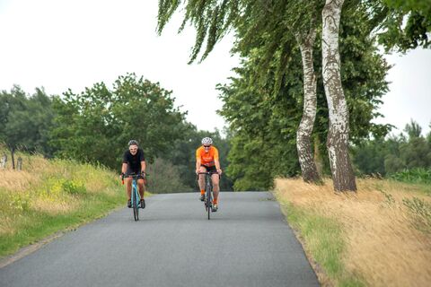 Zwei Rennradfahrer unterwegs auf einsamer Straße 