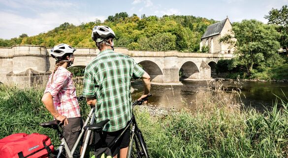 Radfahrer auf dem Werratal-Radweg mit der Werratalbrücke in Creuzburg im Hintergrund