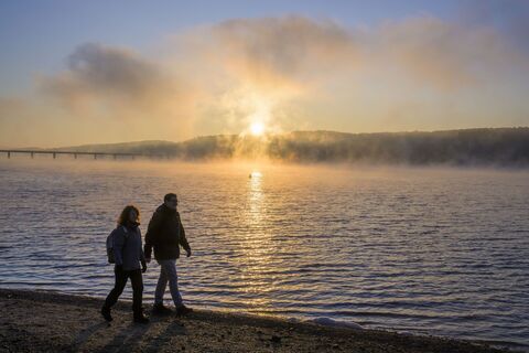 Wanderer am Möhnesee bei Sonnenaufgang