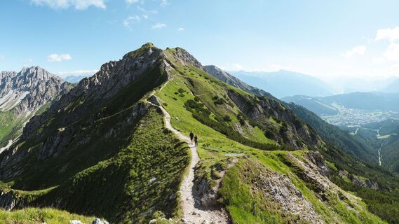 Wanderer auf dem Weg auf die Seefelder Spitze - Blick ins Karwendelgebirge und die Region Seefeld - Panoramabild.jpg