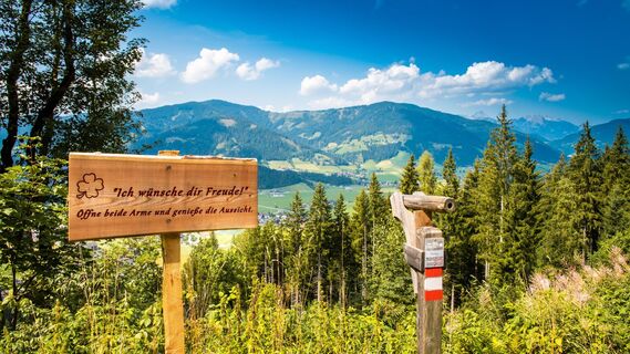 Der Weg der guten Wünsche ist ein wunderschön angelegter Themenwanderweg in Flachau. Für den Rundweg sollte man 3,5 bis 4 Stunden an Gehzeit veranschlagen. Entlang des Weges findet man viele wunderschöne, aussichtreiche Logenplätze und gute Wünsche. Am Bild zu sehen Am Bild zu sehen ist der Ausblick auf Reitdof, das Schild "Ich wünsche dir Freude!" und das Fernrohr, das einen besonderen Aussichtspunkt symbolisiert.