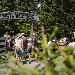 Eingang zum Kunstwanderweg | Besucher:innen beim Eingang zum Kunstwanderweg am Asitz in Leogang.