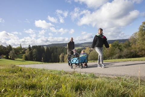 Ein Familie geht auf der AugenBlick-Runde Sulgen, zwei Kinder sitzen im Bollerwagen
