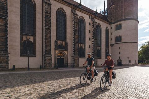 Radfahrer vor der Schlosskirche in Lutherstadt Wittenberg