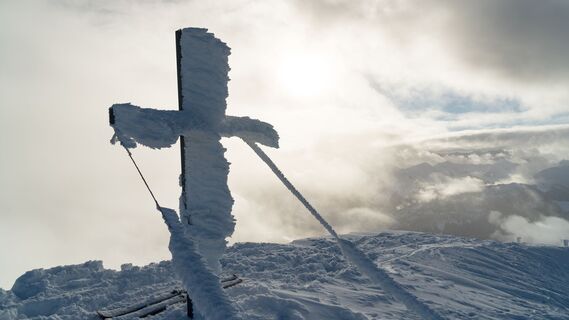 Skitour auf den Juifen mit dem schneebedeckten Gipfelkreuz.