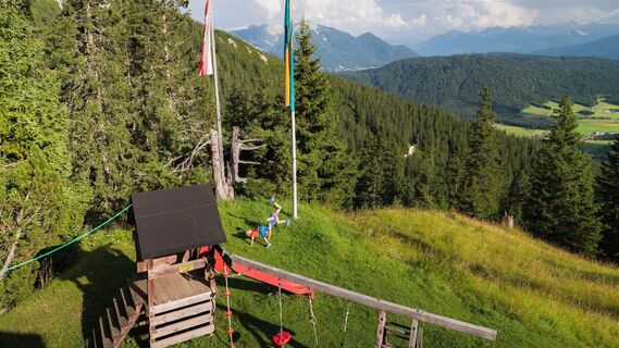 Familien-Weitwanderung im Gaistal - Sohn und Tochter turnen bei Spielplatz von der Wettersteinhütte.jpg