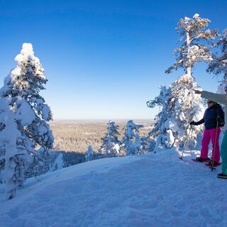 Winterwanderer bewundern die Aussicht auf dem Gipfel des Konttainen