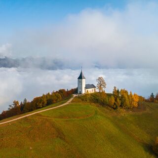 Blick von der Straße vor dem Dorf Jamnik auf die Kirche St. Primus und Felician