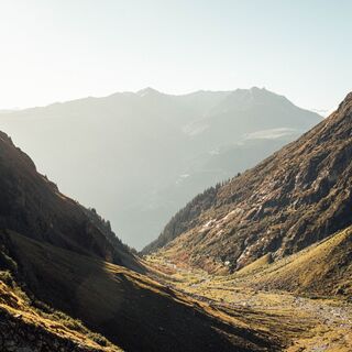 Ein Tal von der Sonne in warmes Licht gebettet.
